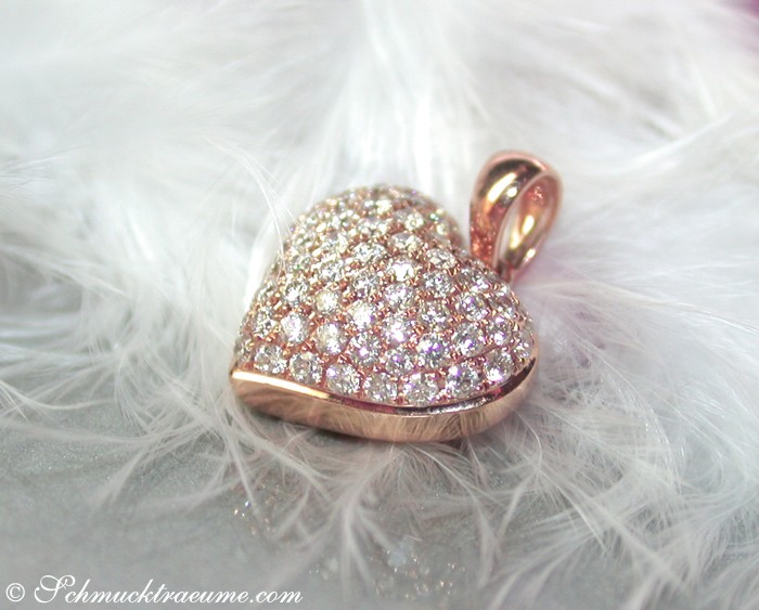 Detailansicht: Herzförmiger Diamant-Anhänger in Roségold 750 auf Federhintergrund