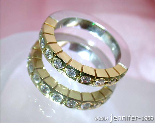 Zwei Diamant-Ringe aus Gelb- und Weißgold, Detailaufnahme, Perspektive von oben, glänzende Kristalle.