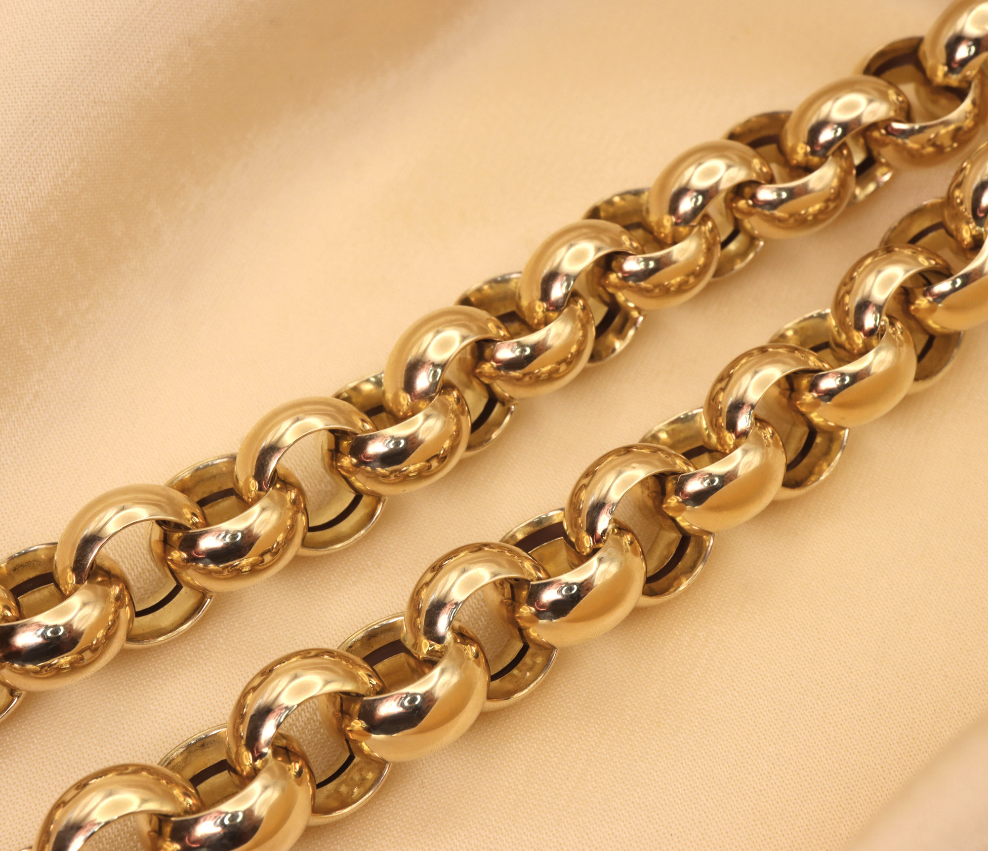 Goldene Halskette aus Gelbgold 585/000, detaillierte Ansicht der geschwungenen Kette auf cremefarbenem Hintergrund