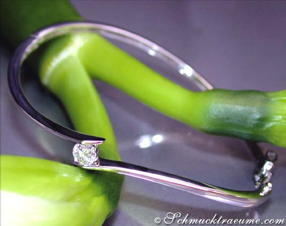 Schlichter Edelarmreif mit Brillant, detailreiches Design, grüne Hintergrundpflanze