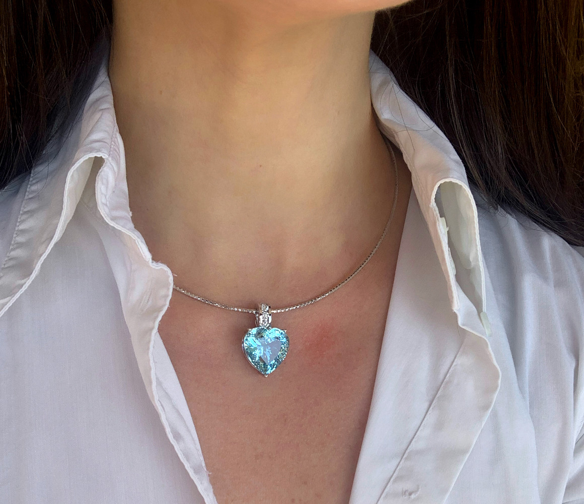 Herz-Anhänger aus Weißgold mit Aquamarin-Brillant, getragen unter offenem Hemd