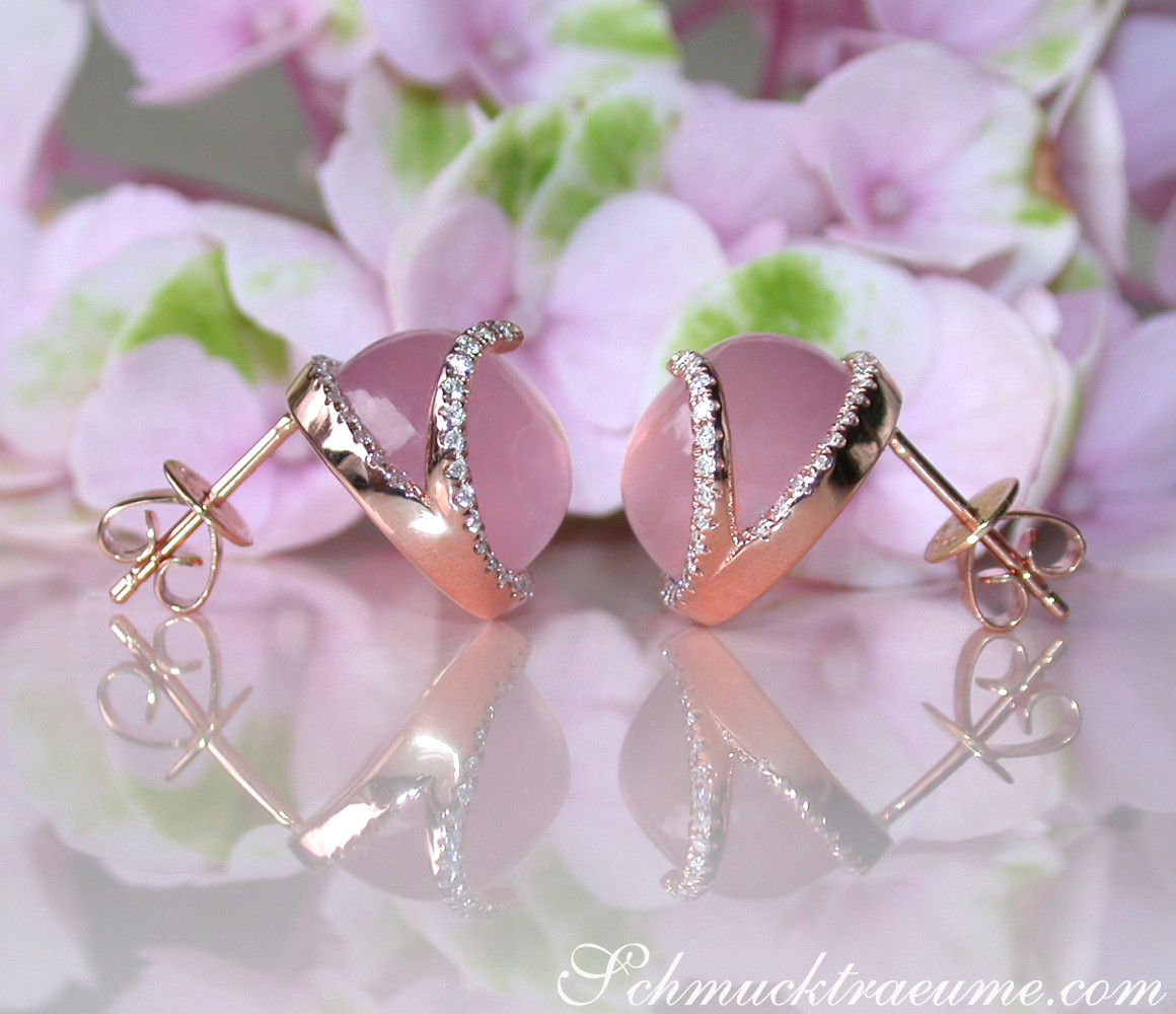 Rosenquarz-Ohrstecker mit Brillanten auf Blütenhintergrund