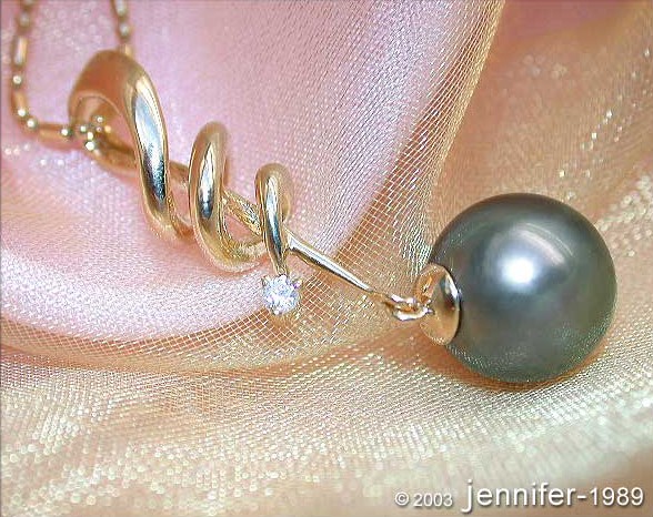 Gelbgold-Anhänger mit Tahitiperle und Brillant, detailreiches Design, elegant aufgehängt.