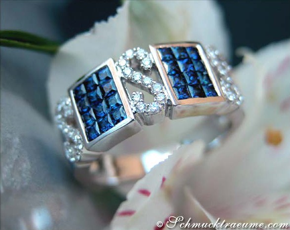 Detailansicht von Saphir-Ring mit Brillanten, Princess-Schliff, Weißgold 585, auf Blumenblüte.