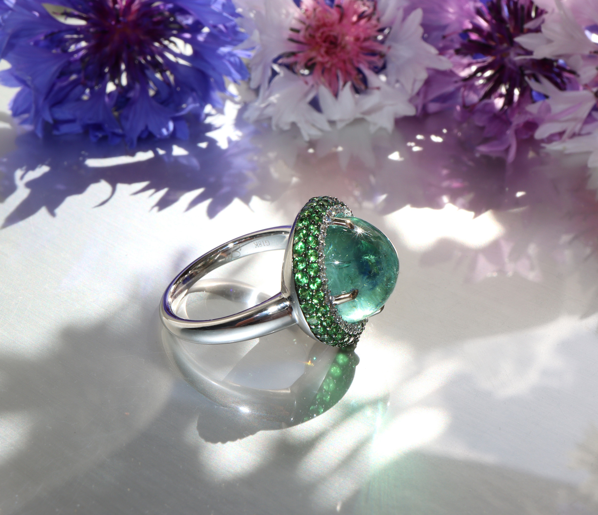 Minz-Turmalin-Ring mit Tsavorite und Brillanten, Detailaufnahme, weißgold, floraler Hintergrund