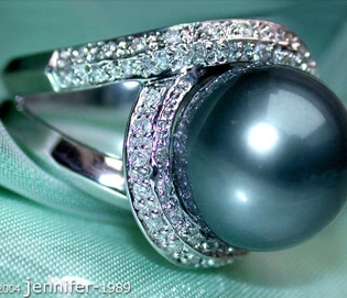 Stattlicher Tahitiperlen-Brillanten-Ring in Weißgold, Detailaufnahme, glänzende Perle, umgeben von Diamanten, auf grünem