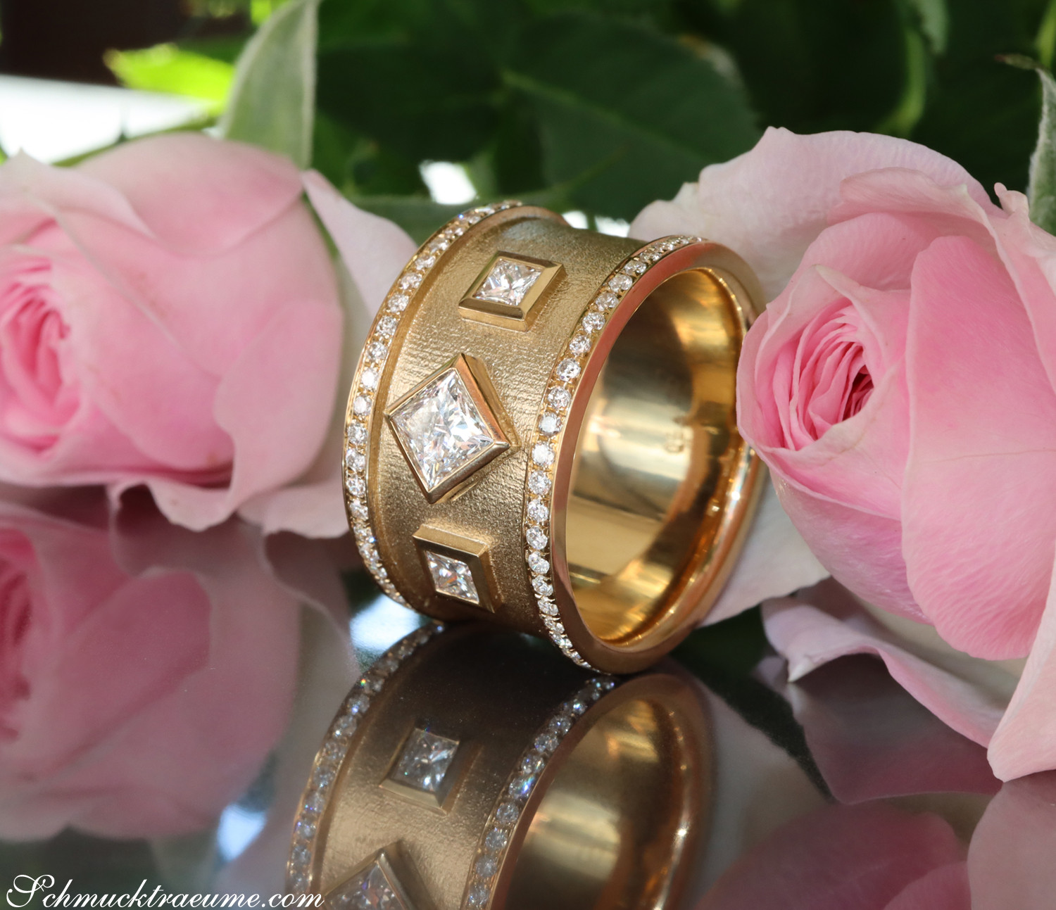 Goldene Diamantringe mit Prinzessenschliff auf Rosenblättern