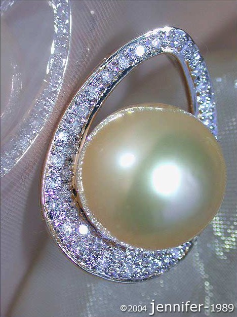 Goldener Perlenanhänger mit Brillanten im Mikimoto-Design, Detailaufnahme auf glänzender Oberfläche.