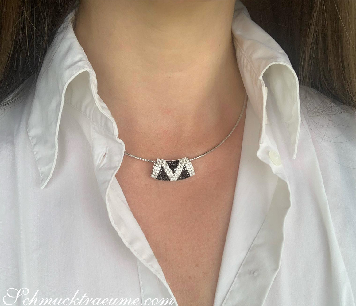 Weißgold-Anhänger mit Zick-Zack-Diamant-Muster, Detailaufnahme, elegant getragen.