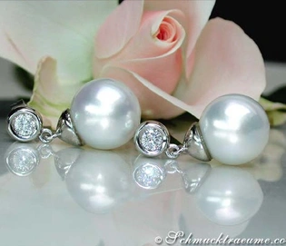 Weißgold-Ohrringe mit Perlen und Brillanten vor Rosenblüte