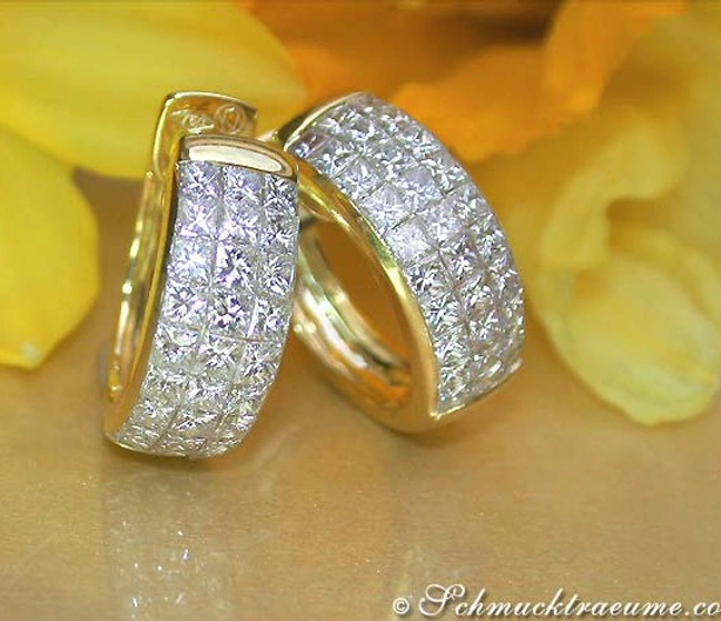 Goldene Creolen mit Prinzessdiamanten auf gelbem Hintergrund Goldene Creolen mit Prinzessdiamanten auf gelbem Hintergrund