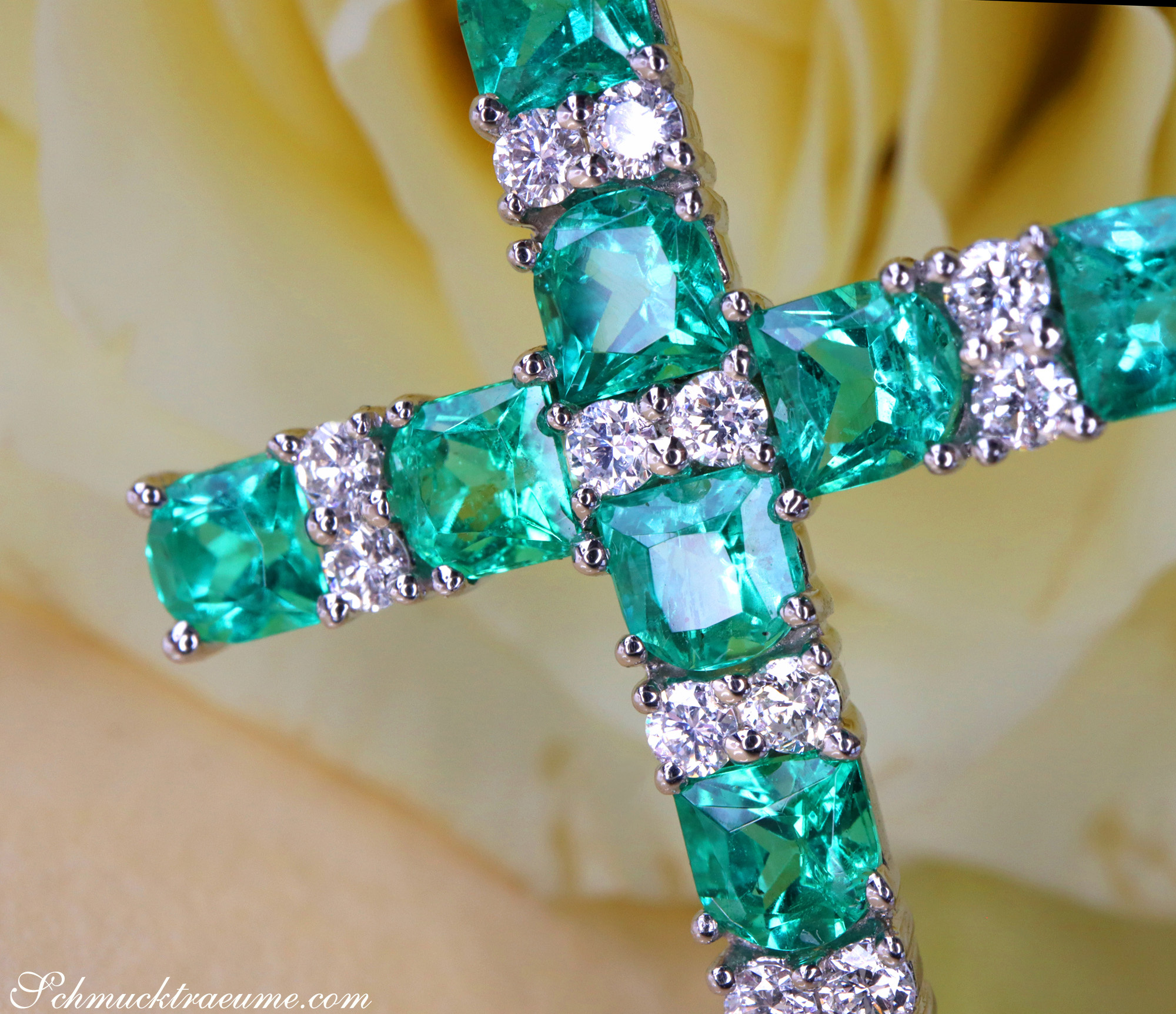 Smaragd Kreuzanhänger mit Brillanten, detailreich, Weißgold 750, auf gelber Blüte.