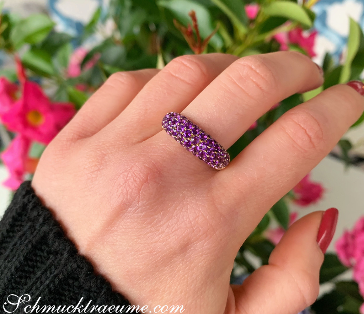 Edler Amethyst Pavéring auf Finger, Hintergrund mit Blüten.