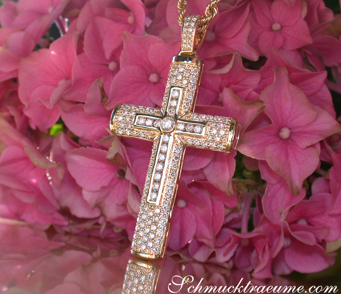 Goldener Kreuzanhänger mit Diamanten in Gelbgold 750, Detailaufnahme vor rosa Hortensienblüten.