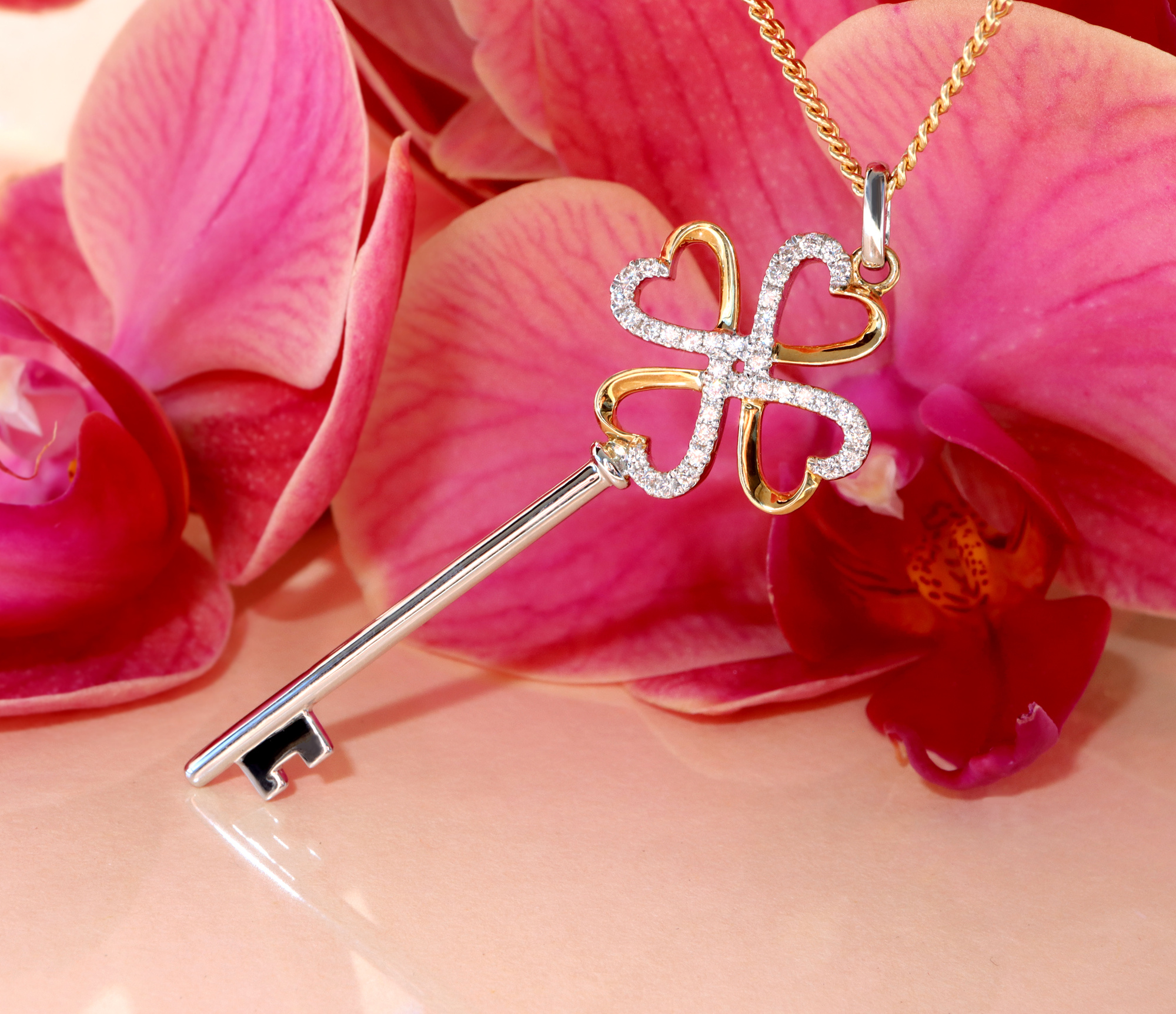 Goldener Schlüsselanhänger mit Brillanten auf Orchideenblüte