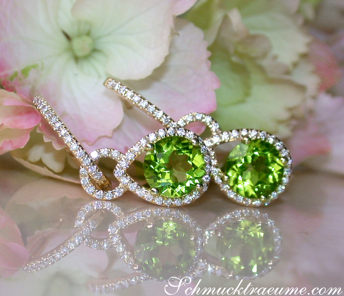 Peridot-Ohrhänger mit Diamantbesatz, Detailaufnahme auf Blütenhintergrund