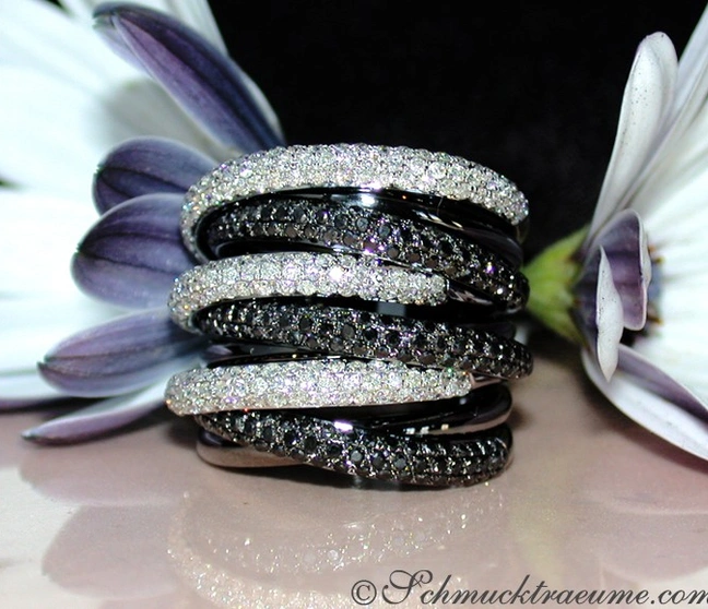 Schwarz-weißer Diamantring mit Blume im Hintergrund Schwarz-weißer Diamantring mit Blume im Hintergrund