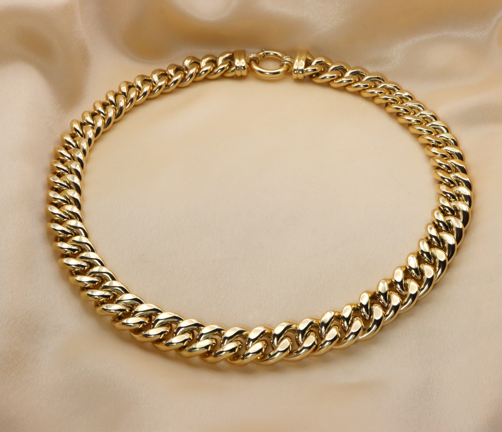 Goldene Panzerkette aus Gelbgold 585, 140 Gramm, auf cremefarbener Seide.