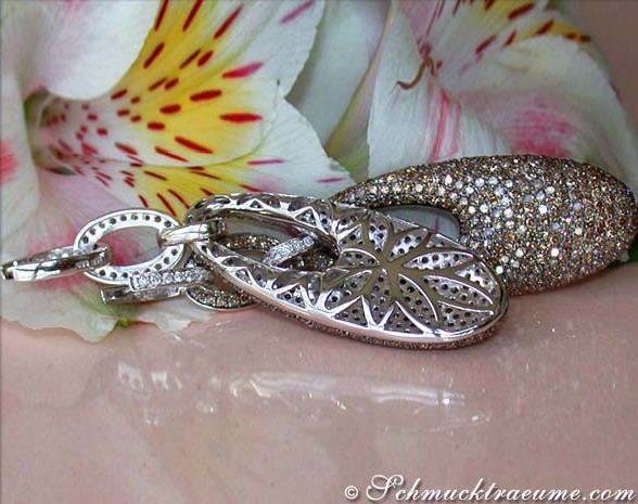 Blumenhintergrund mit silbernen Ohrgehängen, verziert mit braunen und weißen Brillanten.