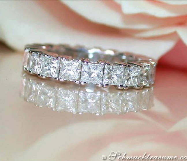 Prinzessdiamant-Ring aus Weißgold mit 20 Diamanten auf Blumenhintergrund Prinzessdiamant-Ring aus Weißgold mit 20 Diamanten auf Blumenhintergrund