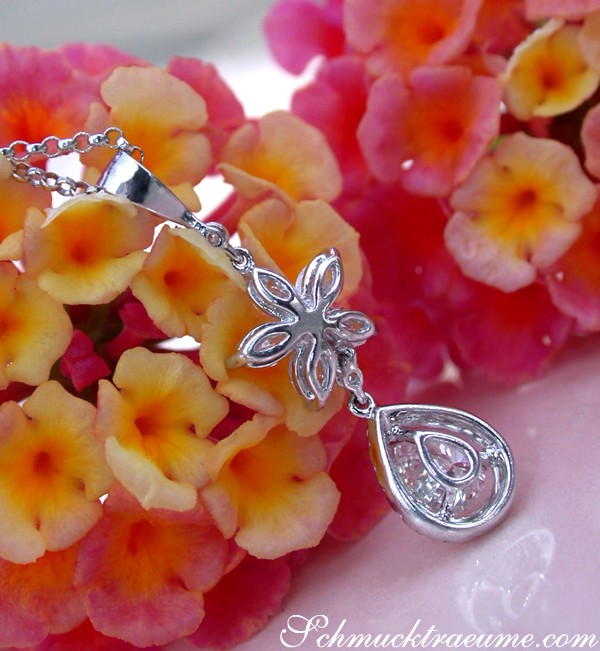 Edler Diamant-Tropfen-Anhänger mit Marquise-Diamanten, detailreich, in Weißgold 750, vor blühendem Hintergrund.