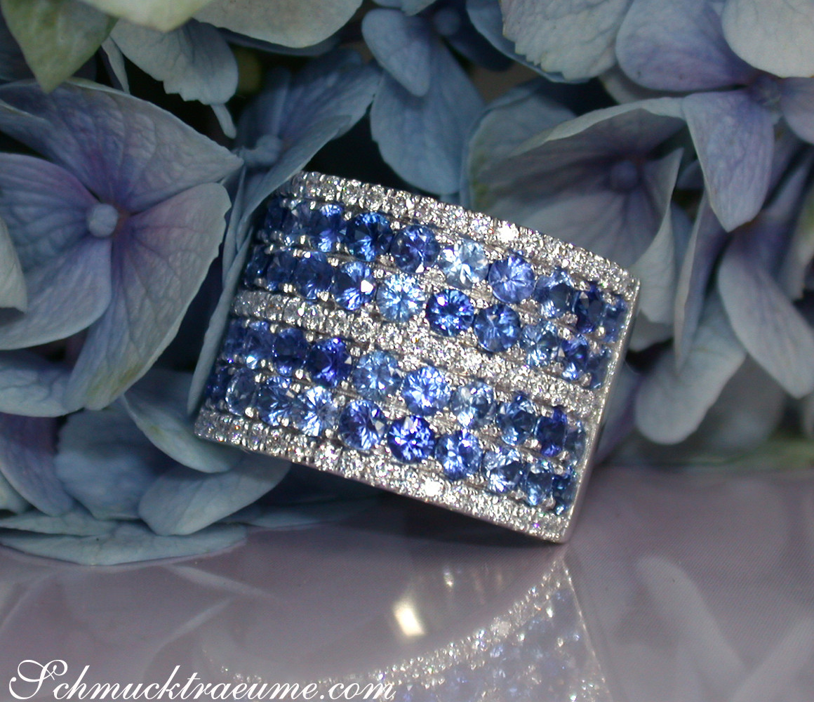 Blauer Saphir-Bandring mit Brillanten, Detailaufnahme, blühende Hortensien im Hintergrund.