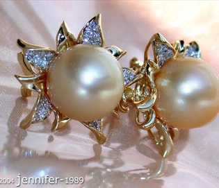 Goldene Südseeperlen-Ohrstecker im Blüten-Design, detailreich verziert mit Diamanten, elegant auf glänzendem Stoff