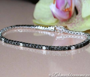 Schwarz-Weiß-Diamant-Tennisarmband mit Orchidee im Hintergrund