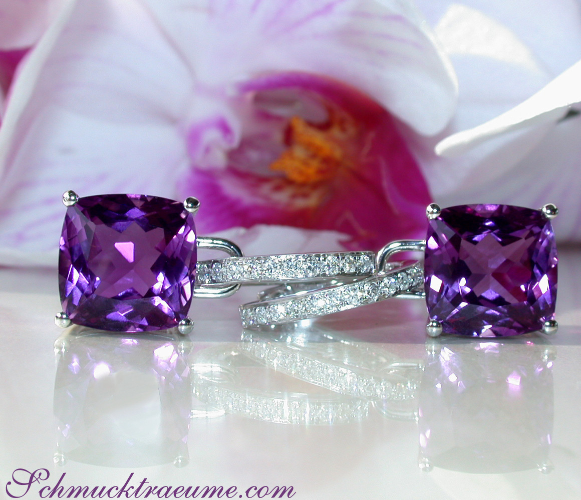 Feminine Amethyst-Kissen-Ohrringe mit Diamanten auf weißem Hintergrund mit Orchideenblüte.