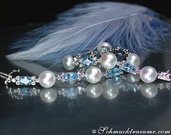Süßwasserperlen-Armband mit Blautopas und Brillanten, detailreich, vor Federhintergrund.