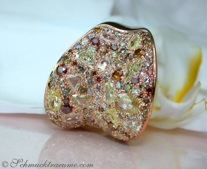 Naturtönige Diamanten im Roségold-Ring, Detailaufnahme auf weißem Hintergrund mit Blume.