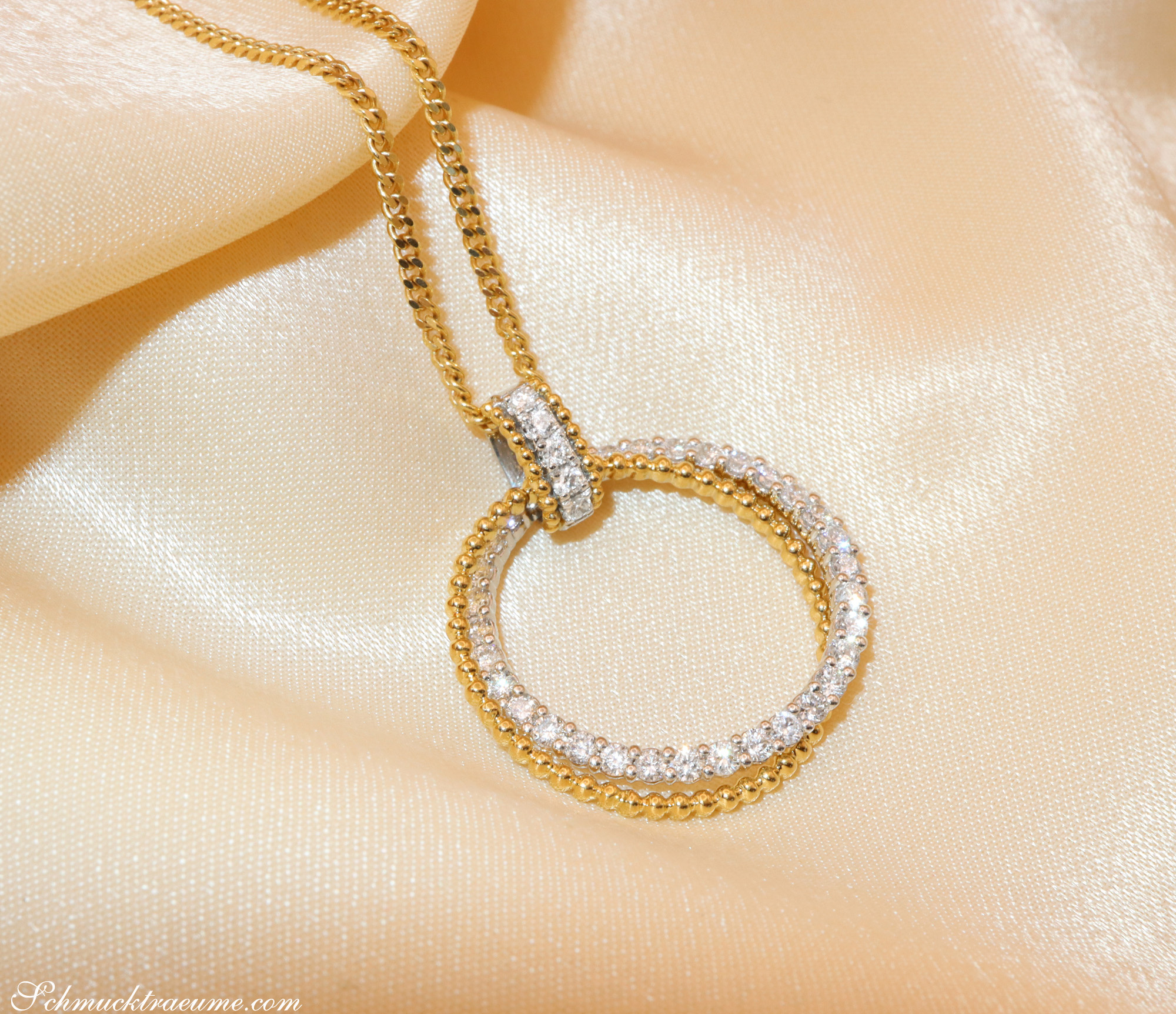 Gelbgold-Anhänger mit funkelnden Brillanten auf samtigem Hintergrund