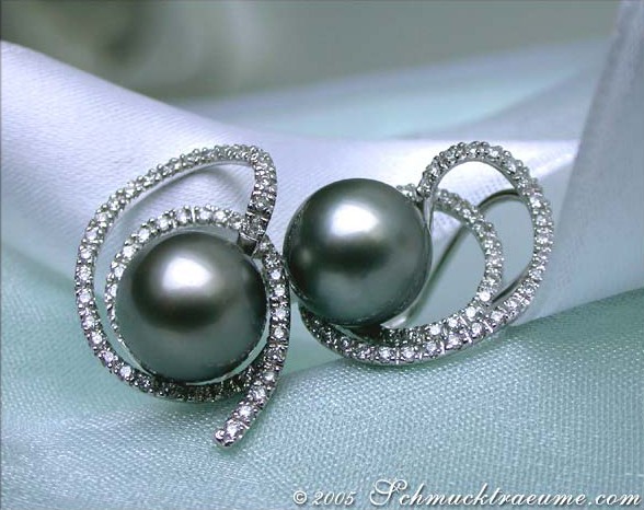 Weißgold-Ohrstecker mit Tahitiperlen und Diamanten, detailreich, elegant auf Satin liegend.
