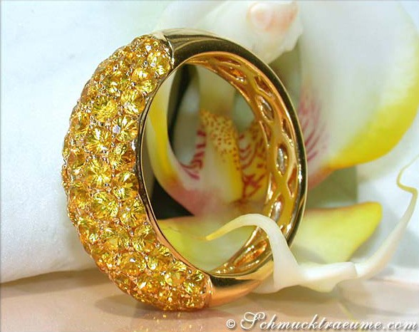 Gelber Saphir Pavéring im Gelbgold 585, Detailaufnahme mit funkelnden Steinen, elegant auf Orchidee gelegt