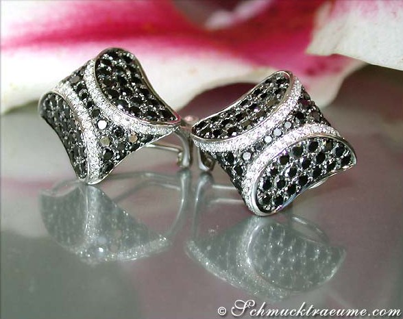 Ohrstecker aus Weißgold mit schwarzen und weißen Diamanten, detailreich, auf glattem Hintergrund.