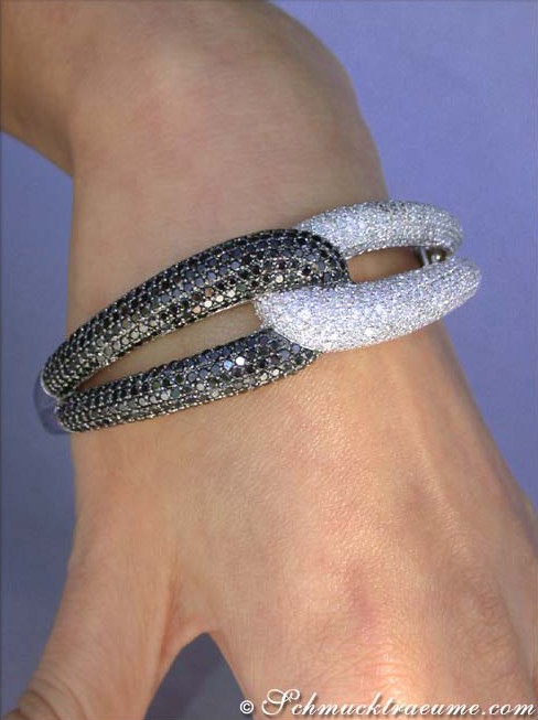 Armreif aus Weißgold mit schwarz-weißen Diamanten, Detailaufnahme, elegant auf Hand getragen