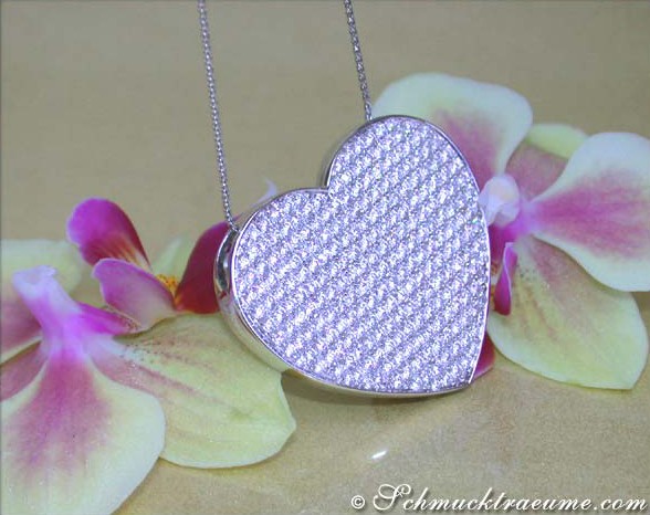 Herz-Form-Collier mit Brillanten in Weißgold 750, makellose Fertigung, vor Orchideenblüten.