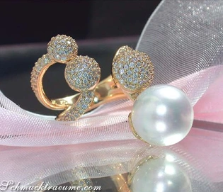 Goldener Ring mit Südseeperle und Brillanten-Pavé-Kugeln auf rosa Schleife.