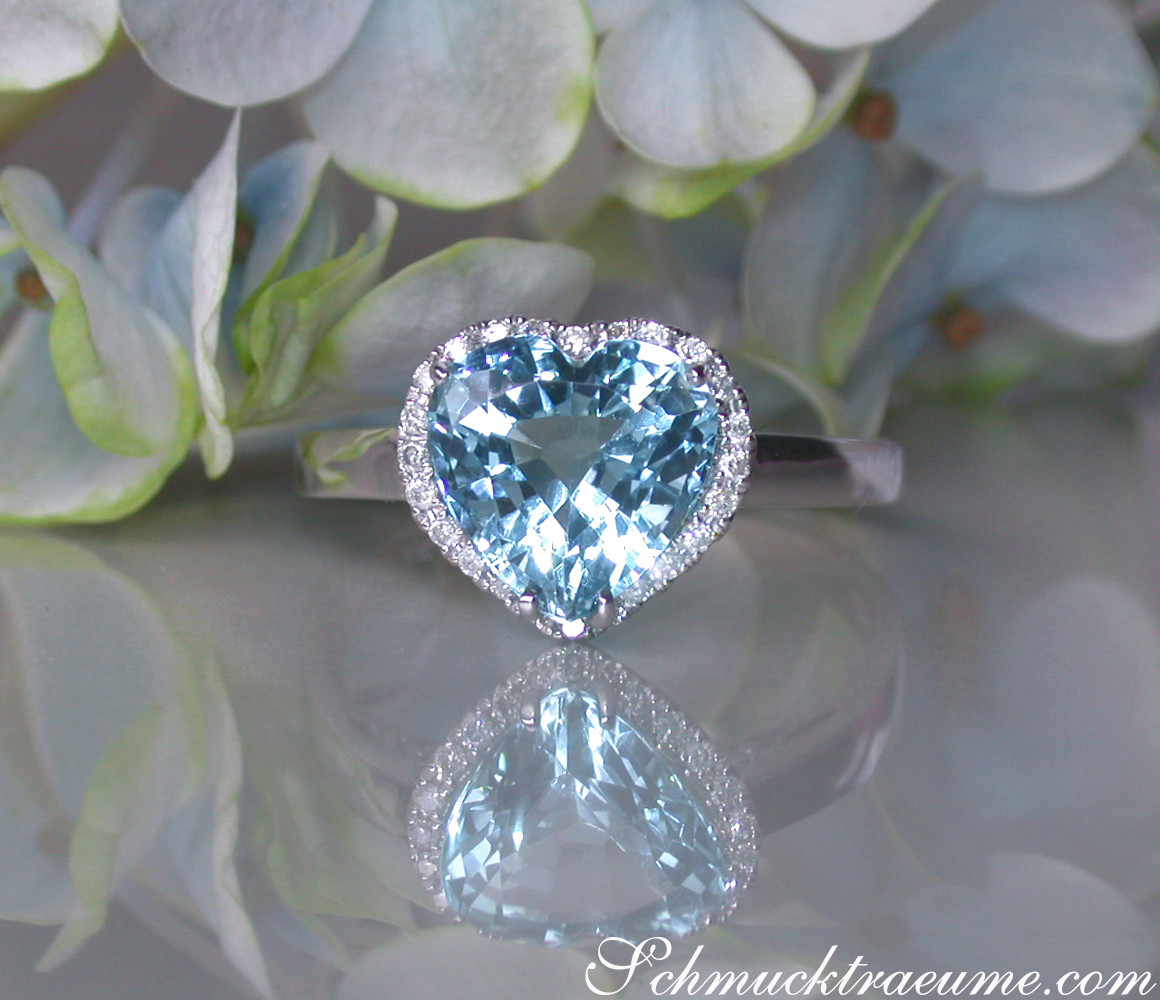 Herzlicher Aquamarin-Ring mit Diamanten auf Blütenhintergrund