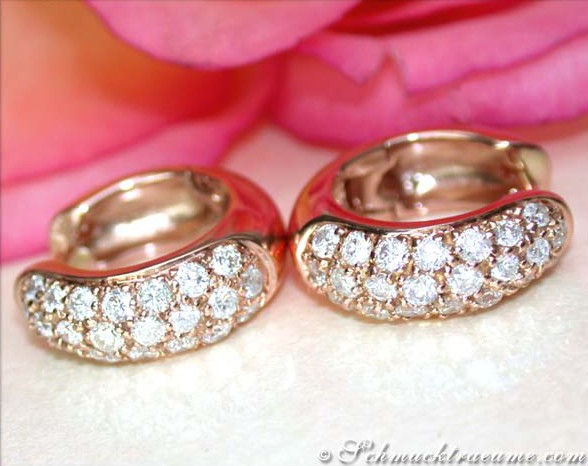 Roségold Creolen mit Brillanten auf Blütenhintergrund