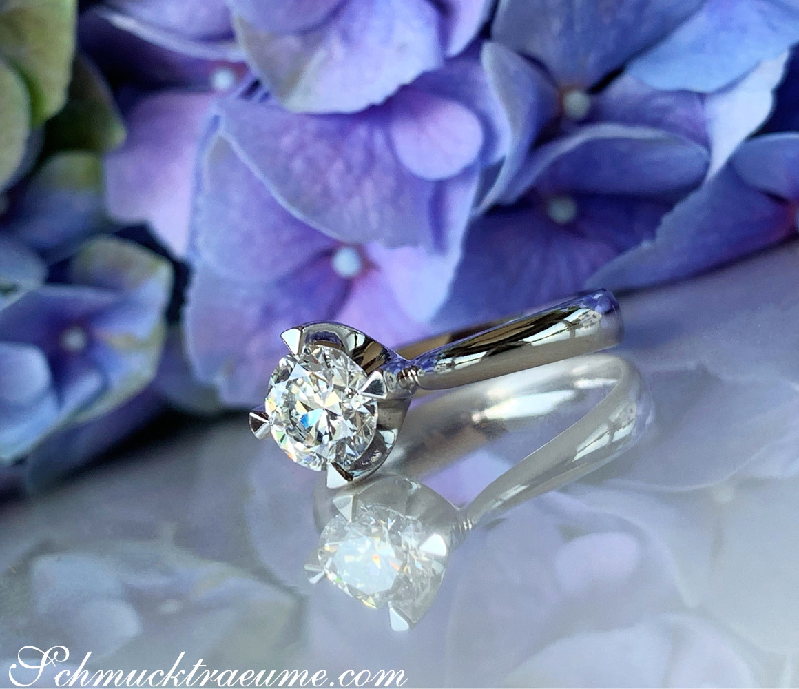 Blauer Hortensien-Hintergrund mit elegantem Solitär-Ring in Weißgold, Detailaufnahme.