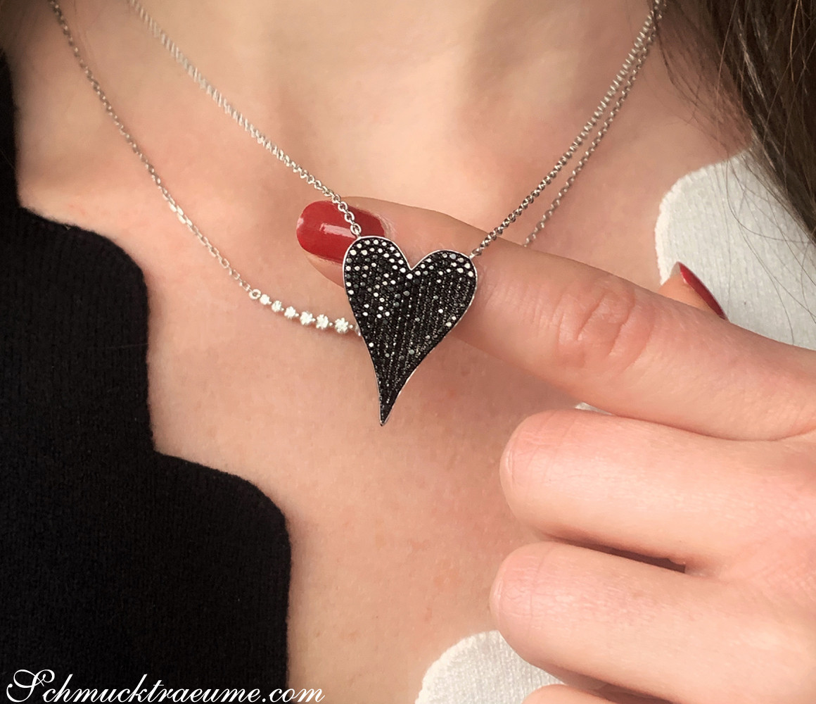 Schwarze Diamanten Herzanhänger auf Halskette, Detailaufnahme mit rotem Nagellack