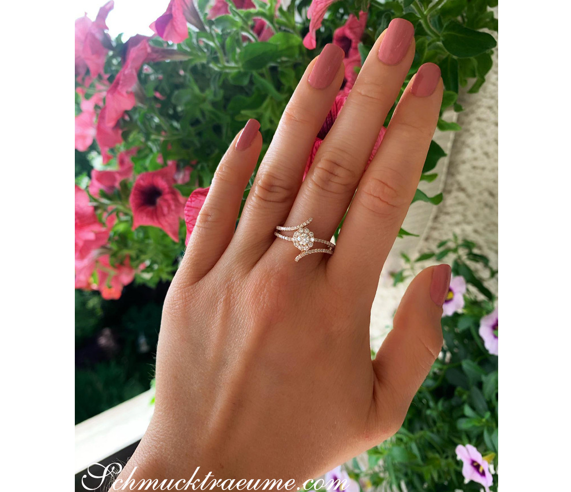 Mini Solitär-Ring mit Brillanten, roségold, Detailaufnahme, zarte Hand, Blumen im Hintergrund