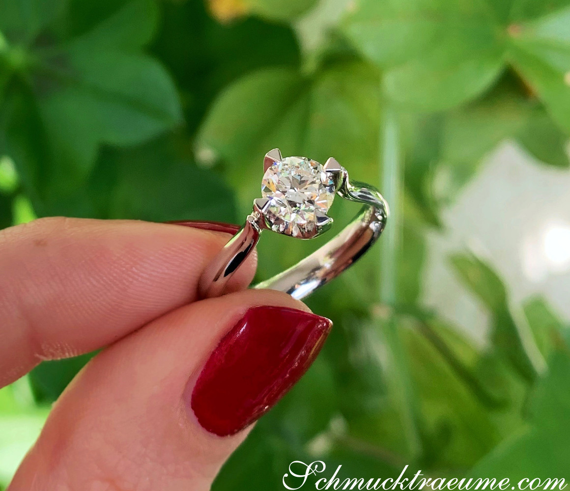 Verlobungsring mit Brillant in Weißgold, Detailaufnahme vor grüner Pflanze