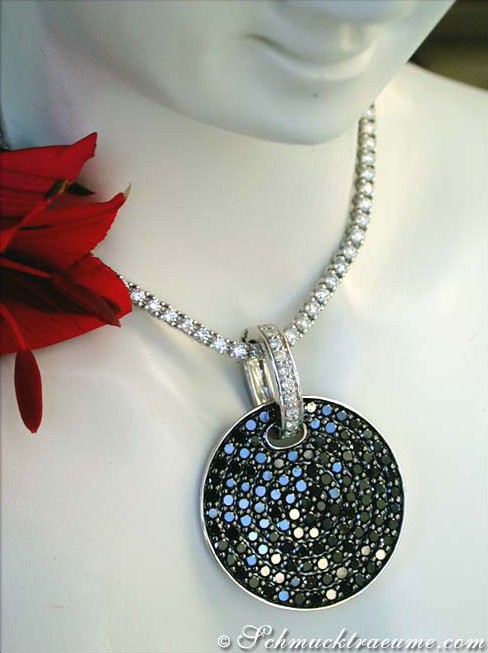 Schwarzer Diamant-Anhänger mit Brillanten, Detailaufnahme auf weißem Halsring, rote Blume im Hintergrund