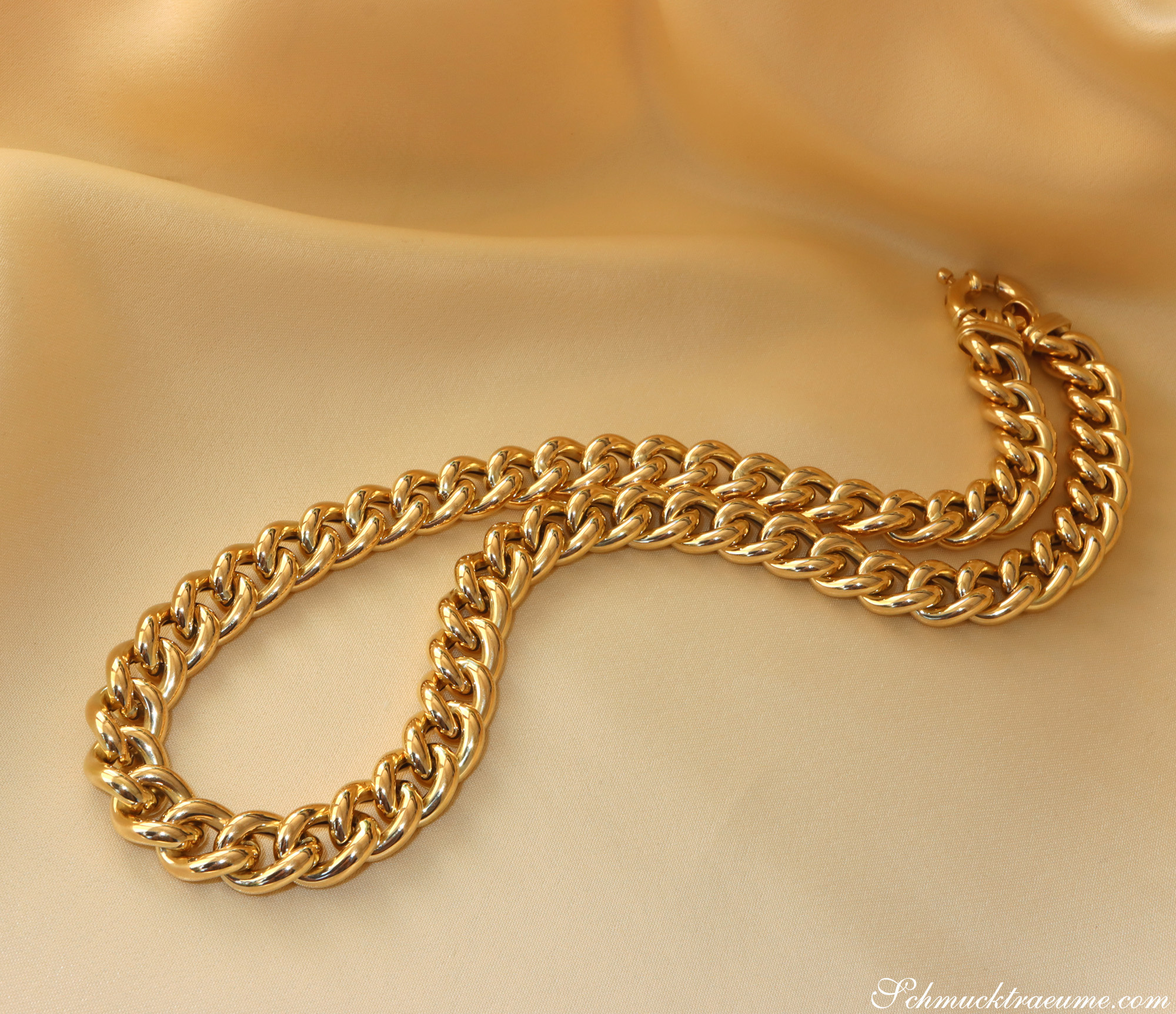 Goldene Panzerkette aus Gelbgold 585, elegantes Statement-Halsband auf cremefarbenem Stoff.