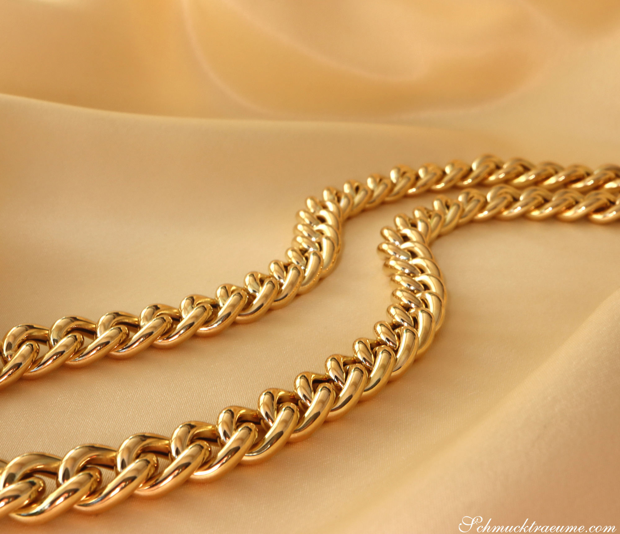 Goldene Panzerkette aus Gelbgold 585, elegant auf cremefarbenem Stoff ausgelegt