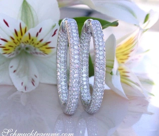 Ovale Diamanten Creolen in Weißgold 585, pavé gesetzt, auf weißem Hintergrund mit Blume