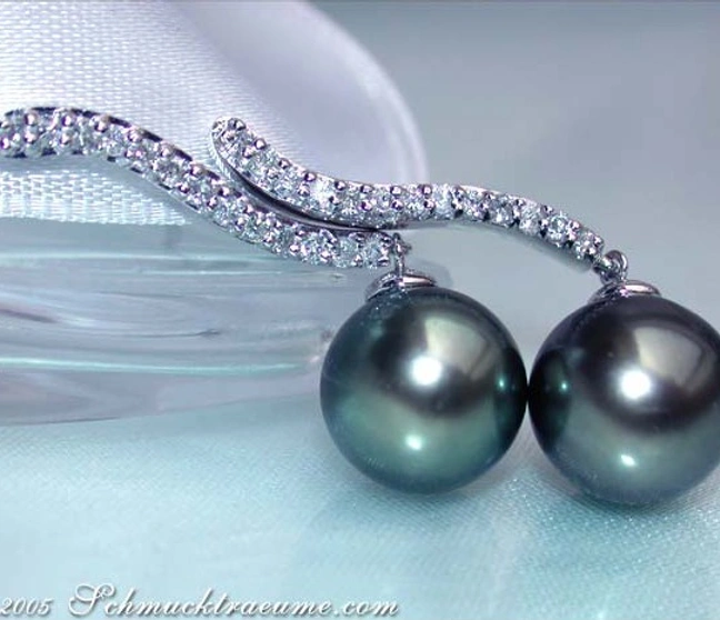 Tahitiperlen-Ohrringe mit Brillanten auf weißem Stoff, elegante Linien und Perlendurchmesser 10-11 mm. Tahitiperlen-Ohrringe mit Brillanten auf weißem Stoff, elegante Linien und Perlendurchmesser 10-11 mm.