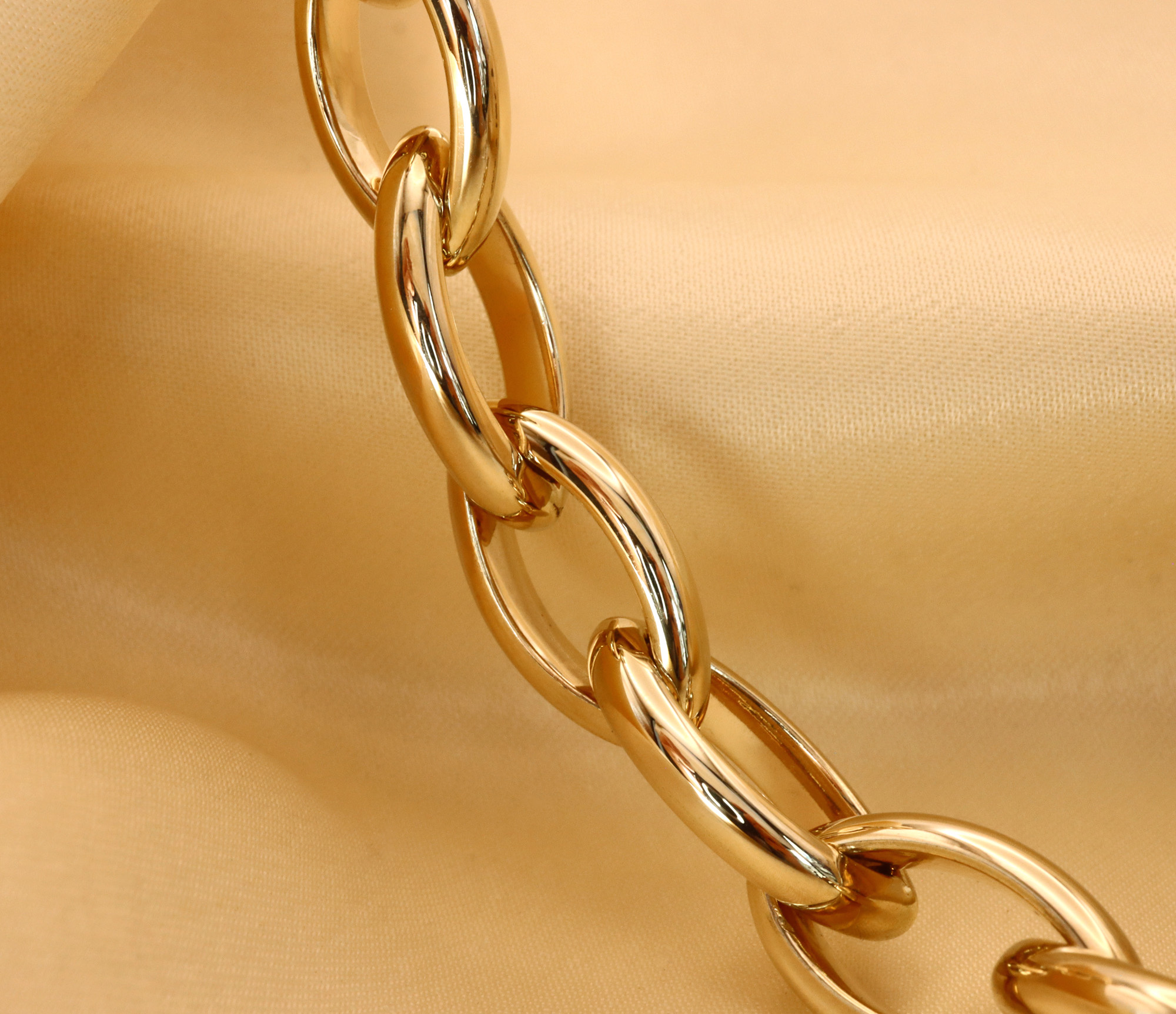 Goldkette aus Gelbgold 585 in Navette-Form, Detailaufnahme auf beige Stoff.
